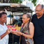 Student couple on tour Tipico Dominicano at a fruit stand with their Spanish teacher.