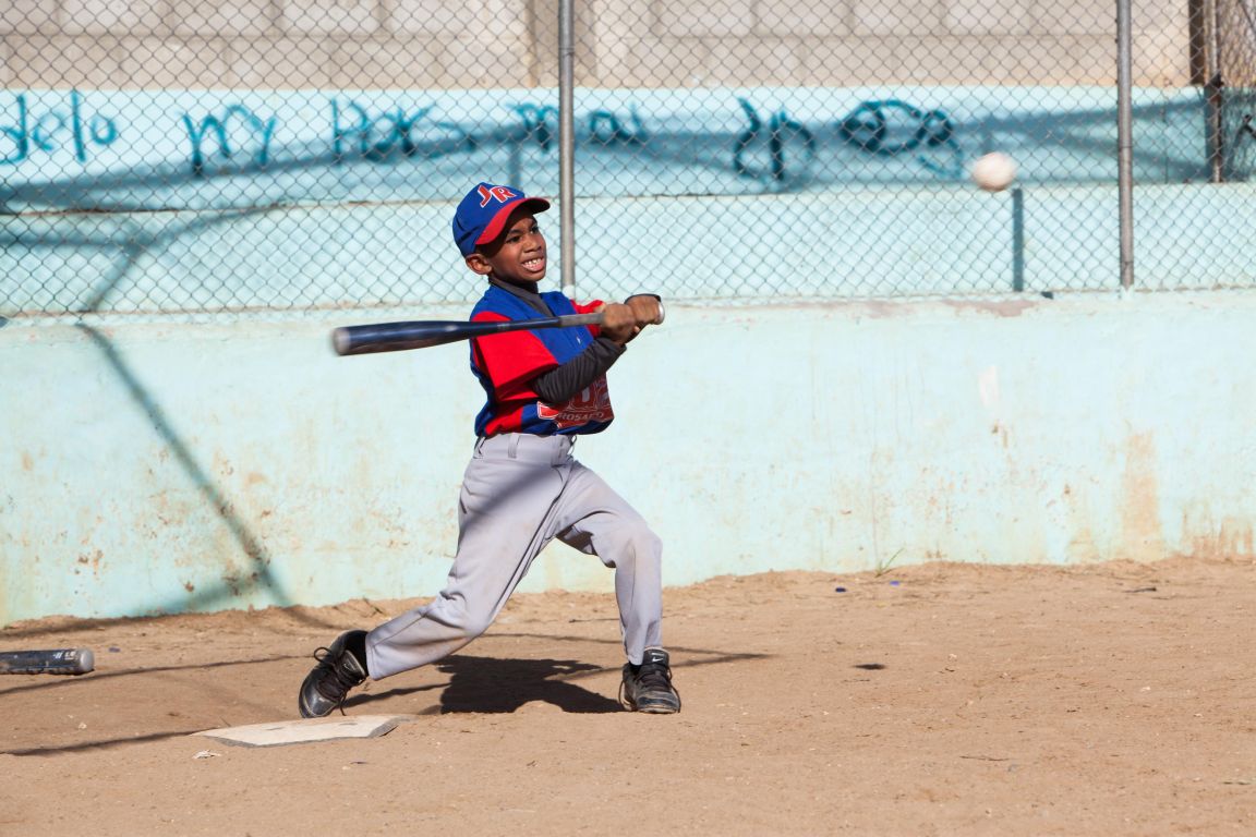 A Dominican boy is playing baseball which is an important part of Dominican every-day culture and talked about the cultzure class at IIC Spanish School in the Dominican Republic.