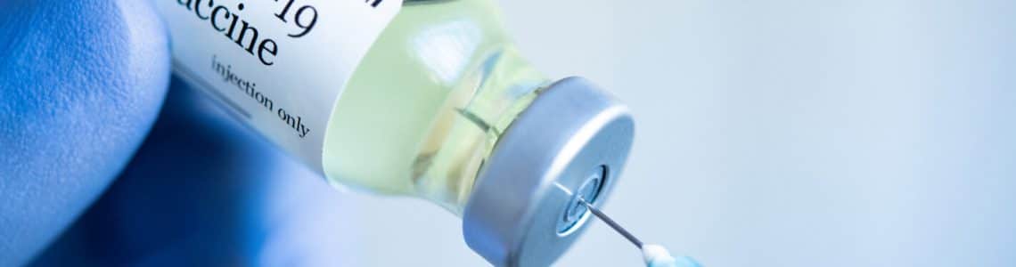 Covid-19 vaccination picture shows ampoule and needle.