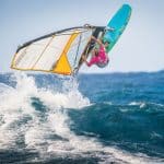 Windsurfer jumps and rides the waves, representing one of the disciplines of the Master of the Ocean watersports contest in Cabarete, Dominican Republic.