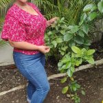 Spanish Teacher Denny standing beside the orange tree that has been planted for National Tree Day in 2022 and is growing since then in the garden of IIC Spanish School in Sosua Dominican Republic.