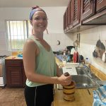 Spanish student smashing spices during Dominican cooking class at IIC Spanish School Dominican Republic